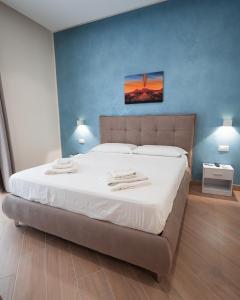 那不勒斯Nazzarooms的卧室里有一张铺着白色床单的大床