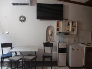 a dining room with a table and chairs and a tv at Relax in Gevgelija