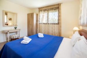 une chambre avec un lit bleu avec des serviettes dessus dans l'établissement GREEN and BLUE VILLA, à Glykadi