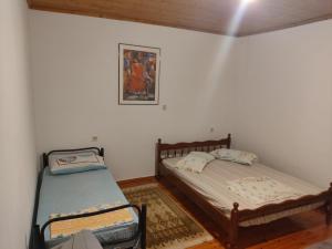 a bedroom with two beds and a picture on the wall at Relaxhouse in Himare
