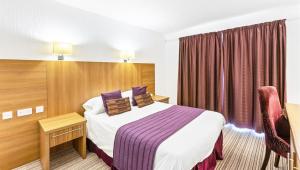 a hotel room with a bed and a chair at Sandy Lodge Hotel Newquay in Newquay