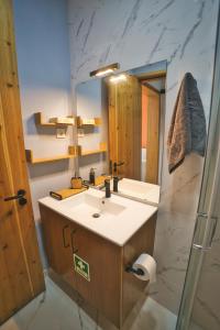 ein Badezimmer mit Waschbecken und Spiegel in der Unterkunft Coração da Quinta in Algarvia