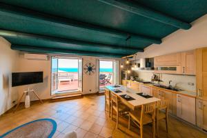 a kitchen with a table and chairs and a view of the ocean at ALBACHIARA by CefaLux in Cefalù