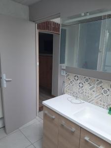 Un baño con lavabo y un espejo grande. en Chez Robert, en Le Mée 8 fotos más