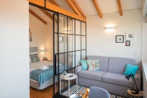 een woonkamer met een bank en een bed bij Panoramic luxury apartment w AC Downtown and Metro in Porto