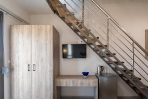 a living room with a tv and a staircase at Majestic house in Neos Marmaras