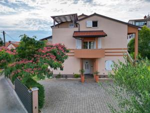 a house with pink flowers in front of it at Premium Apartments Tade Funtana in Funtana