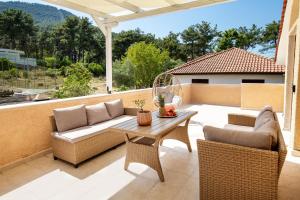une terrasse avec deux canapés et une table dans l'établissement GREEN and BLUE VILLA, à Glykadi