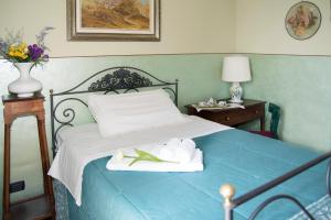 - une chambre avec un lit bleu et des serviettes dans l'établissement B&B Casa Carla, à Pignerol