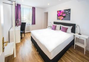 a hotel room with a large bed and a desk at Hotel Storchen in Ravensburg