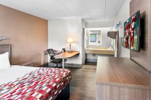 a hotel room with a bed and a desk at Red Roof Inn Indianapolis North - College Park in Indianapolis +22 photos