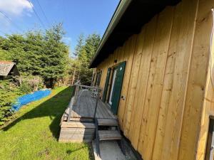 a wooden building with a porch with a green door at Heidi-Alm-Amelie am Präbichl in Vordernberg