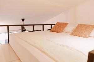 un lit blanc avec deux oreillers dessus dans l'établissement chic and cozy studio, à Canggu