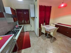 a kitchen with a table and a kitchen with red cabinets at La casa di Cisotta in Fivizzano +3 photos