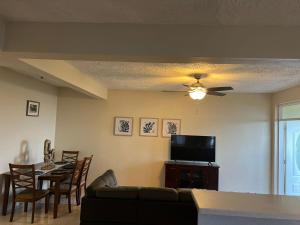 a living room with a couch and a tv and a table at Ocean Breeze Comfort in East End