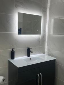 a white bathroom with a sink and a mirror at The Old Stable, Rustic Charm Modern Comforts in Gorfield