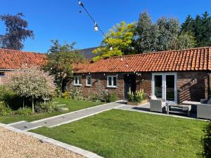 a brick house with a garden and a lawn at The Old Stable, Rustic Charm Modern Comforts in Gorfield