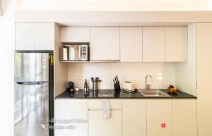 a kitchen with white cabinets and a stainless steel refrigerator at Kukun Reforma & Downtown in Mexico City