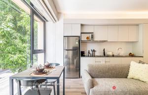 a kitchen and living room with a table and a refrigerator at Kukun Reforma & Downtown in Mexico City