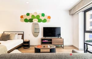 a living room with a couch and a tv at Kukun Reforma & Downtown in Mexico City