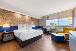a hotel room with a large bed and a desk at GLō Best Western Kanata Ottawa West in Ottawa +23 photos