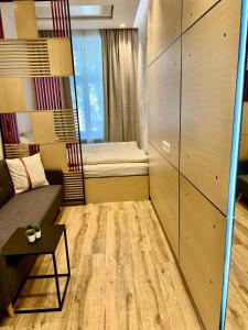a small room with a couch and a bed at Vienna Charm Apartments Landstraße in Vienna