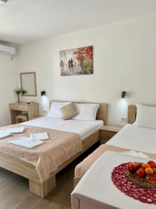 a hotel room with two beds and a bowl of fruit at Apartmani Juković in Ulcinj