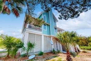 a blue house with palm trees in front of it at Sweet Carolina in Edisto Island