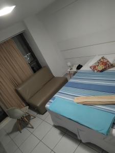 a small room with two beds and a chair at Flat BV Beira-Mar - Edf Beach Class EXECUTIVE Apart-Hotel 507 in Recife +50 photos