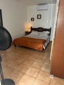 a bedroom with a bed and a tiled floor at Casa Atalaia in Arraial do Cabo