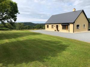 een huis met een groot gazon ervoor bij Lissyclearig Lodge in Kenmare