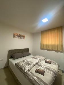 a bedroom with a large bed with a window at Apartman Green Vlašić in Šišava