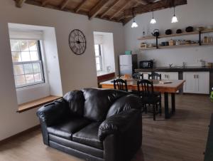 a living room with a leather couch and a table at Casa da Tia Avelina in Angra do Heroísmo
