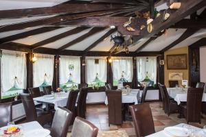 a dining room with tables and chairs and windows at La Bucovineanca in Strîmtura