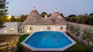dom z basenem przed nim w obiekcie Il Trullo della Rondinina w Alberobello