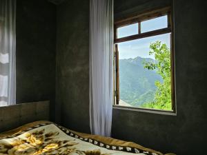 a bed in a room with a window at Maikostan in Shuakhevi