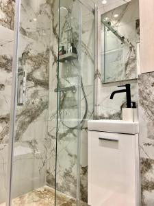 a bathroom with a glass shower and a sink at Vienna Charm Apartments Landstraße in Vienna