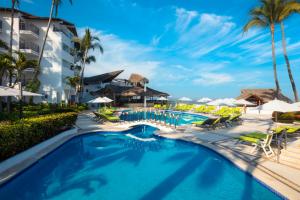 a pool at a resort with chairs and umbrellas at Buenaventura Grand Hotel & Great Moments - All Inclusive in Puerto Vallarta