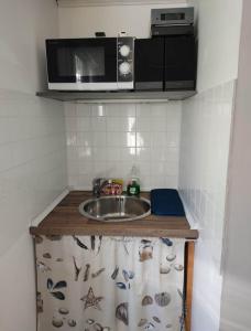 a kitchen counter with a sink and a microwave at Estudio independiente in Hendaye +1 photo