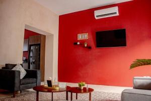 a living room with a red wall at Casa 59, con alberca en el centro in Campeche