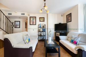 a living room with two couches and a tv at Mirador del Guadalhorce in Alora