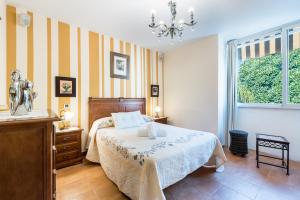 a bedroom with a bed and a dresser and a window at Mirador del Guadalhorce in Alora