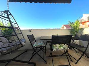 a patio with chairs and a table on a balcony at Apartment New Chic in Supetar