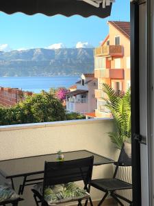 a balcony with a table and chairs and a view of the water at Apartment New Chic in Supetar