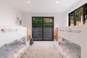 two bunk beds in a room with a doorway at Anaka in Wanaka