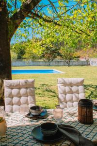 a table with plates and bowls on top of it at Just Like Home - Casa de Cimo de Vila in Vila Nova de Cerveira