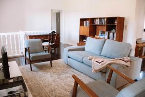 a living room with a blue couch and a chair at Just Like Home - Casa de Cimo de Vila in Vila Nova de Cerveira