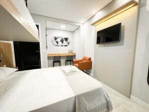 a bedroom with a large white bed and a television at Hotel São José in São José