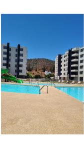 une piscine dans une ville avec de grands immeubles dans l'établissement Departamento 2H 1B en Punta Puyai, à Papudo