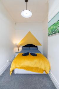 a bedroom with a yellow bed with a yellow blanket at 5 Star Homes- Free Wifi & Parking, Contractor & family friendly in Pallion +29 photos